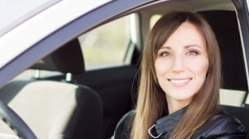 Young woman behind the wheel of her car