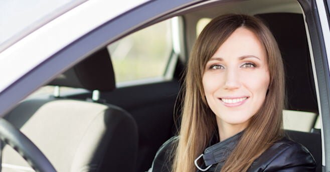 Young woman behind the wheel of her car